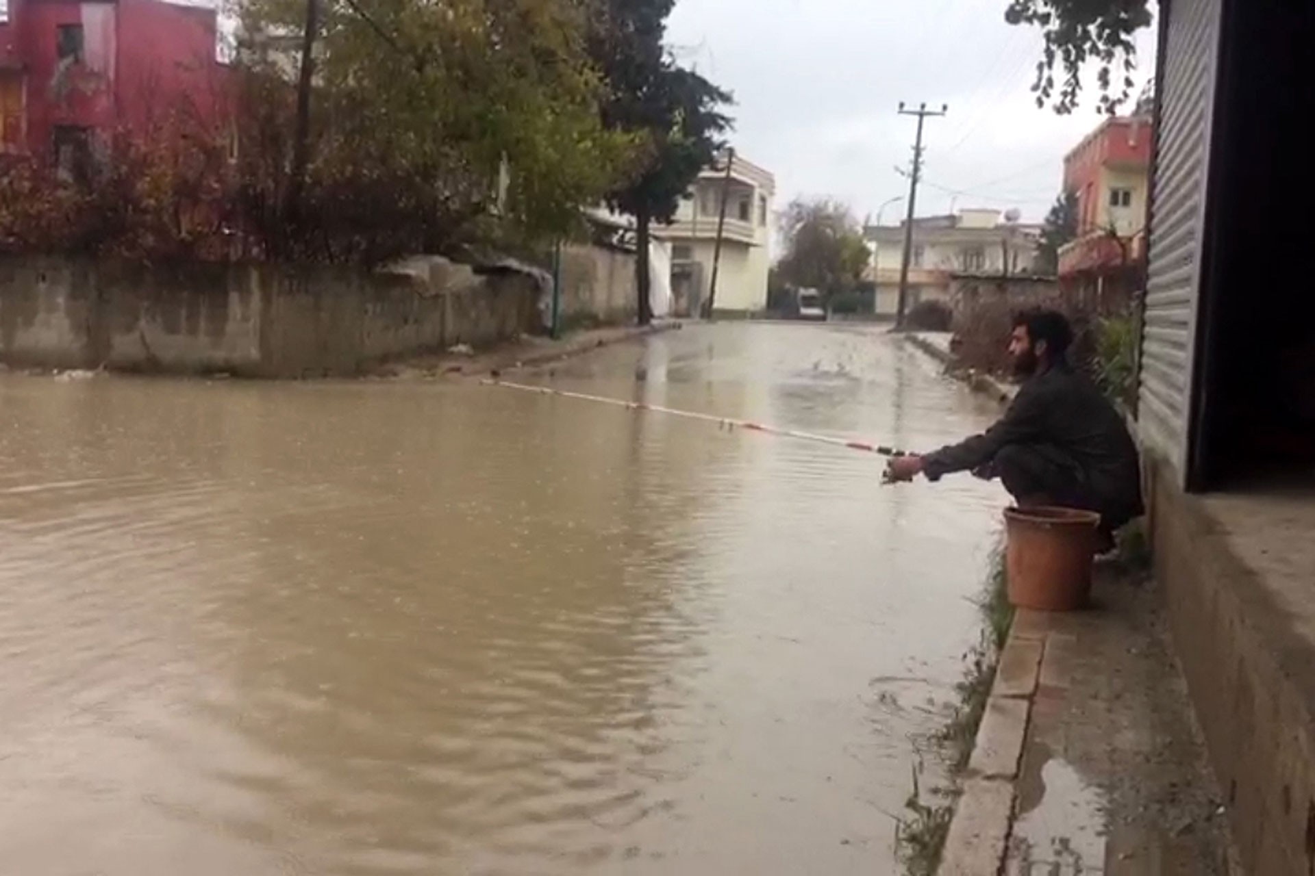 Mersin'de bir yurttaş su basan yolda olta attı