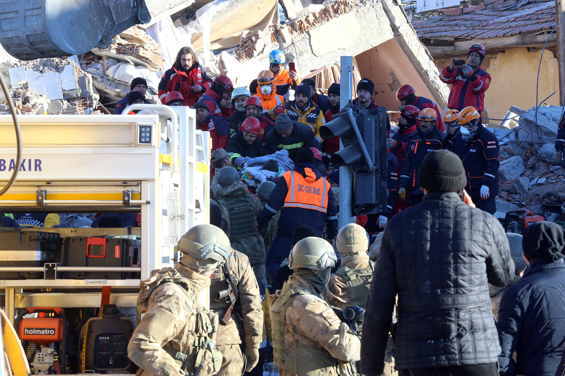 Ekipler, deprem sonucu yıkılan bir binanın enkazından küçük bir çocuğu çıkarıyor