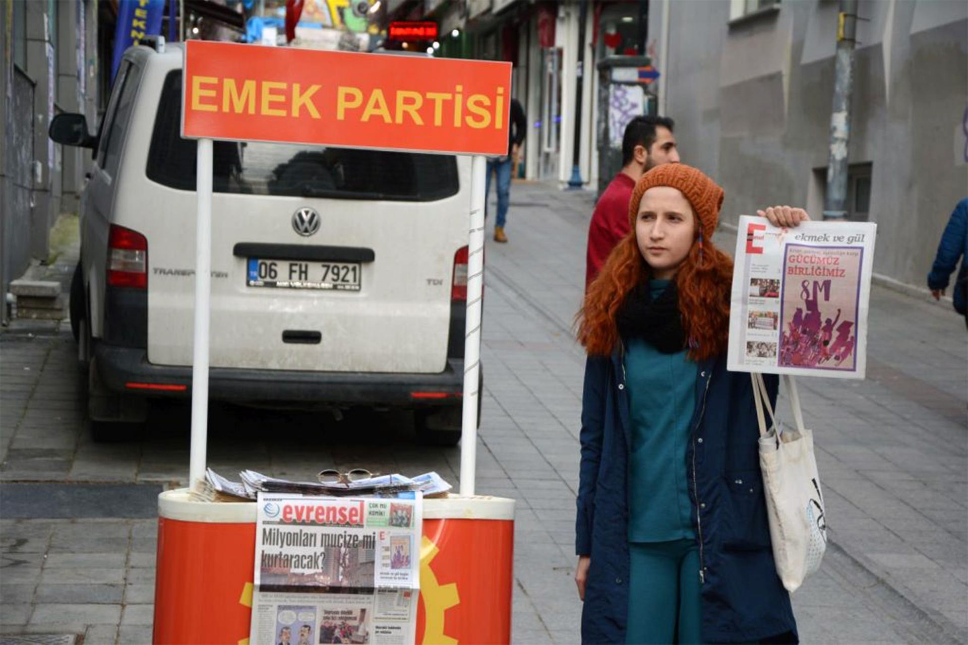 Emek Partisi standı ve önünde Ekmek ve Gül eki tutan bir genç