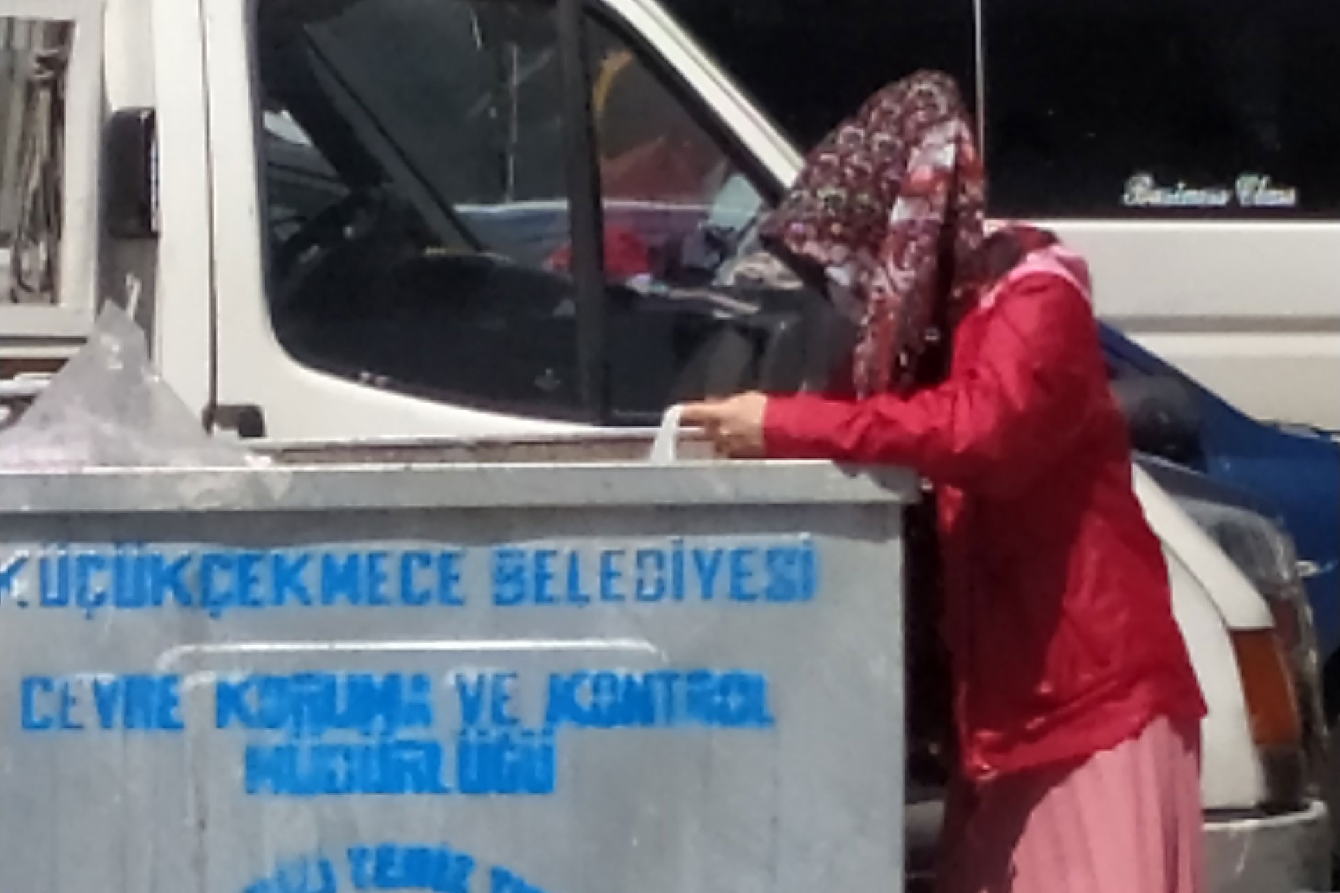 Çöp konteynerinden yiyecek toplayan kadın