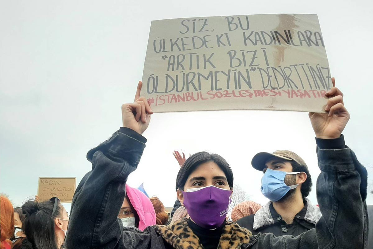 İstabul Sözleşmesi pankartı taşıyan bir kadın.