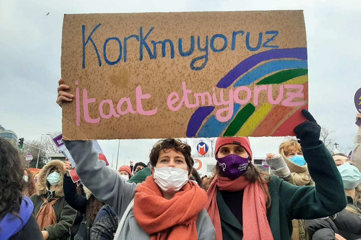 Korkmuyoruz itaat etmiyoruz pankartı taşıyan bir kadın.