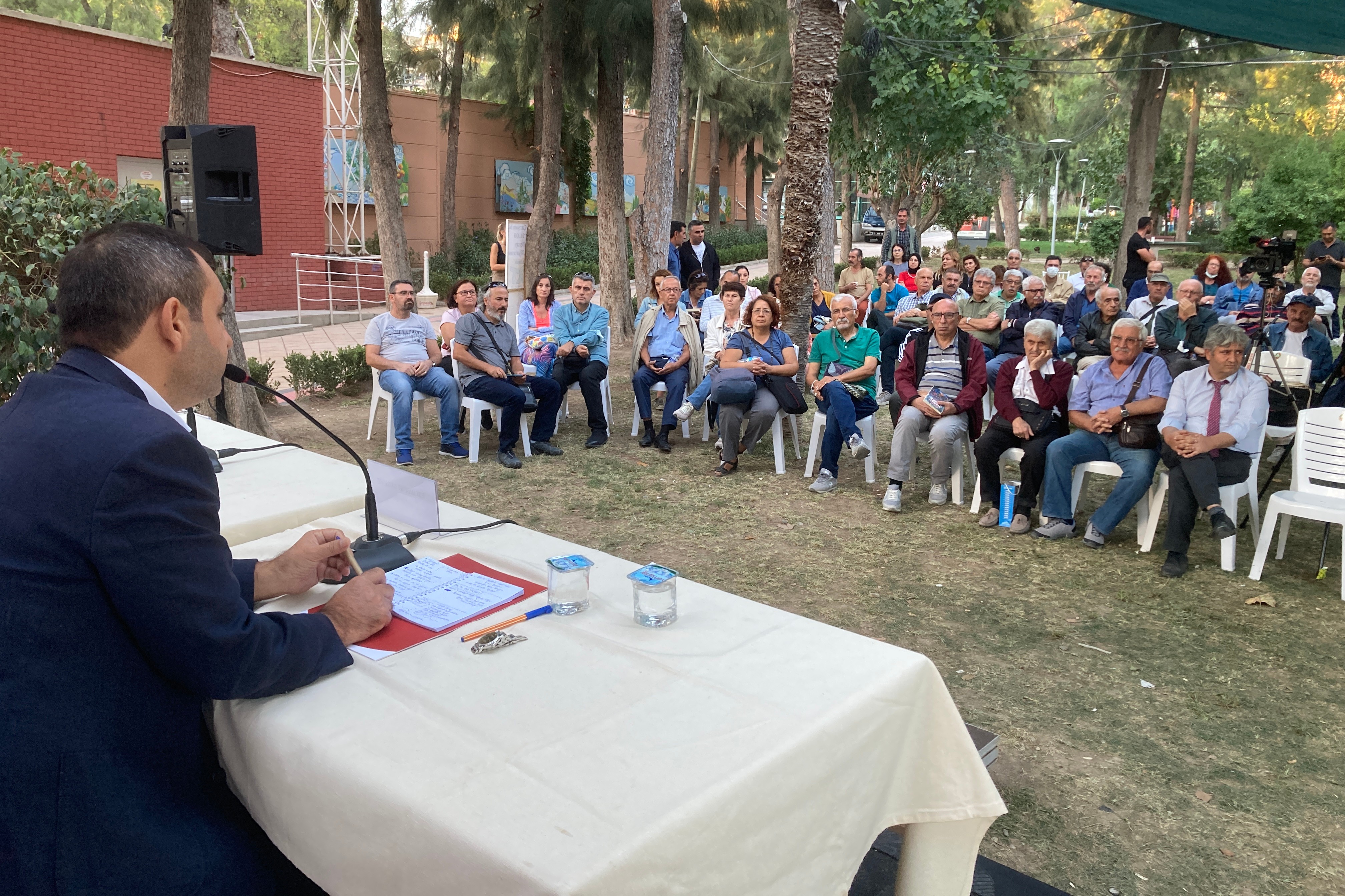 yeşil alanda sandalyede oturan insanlar