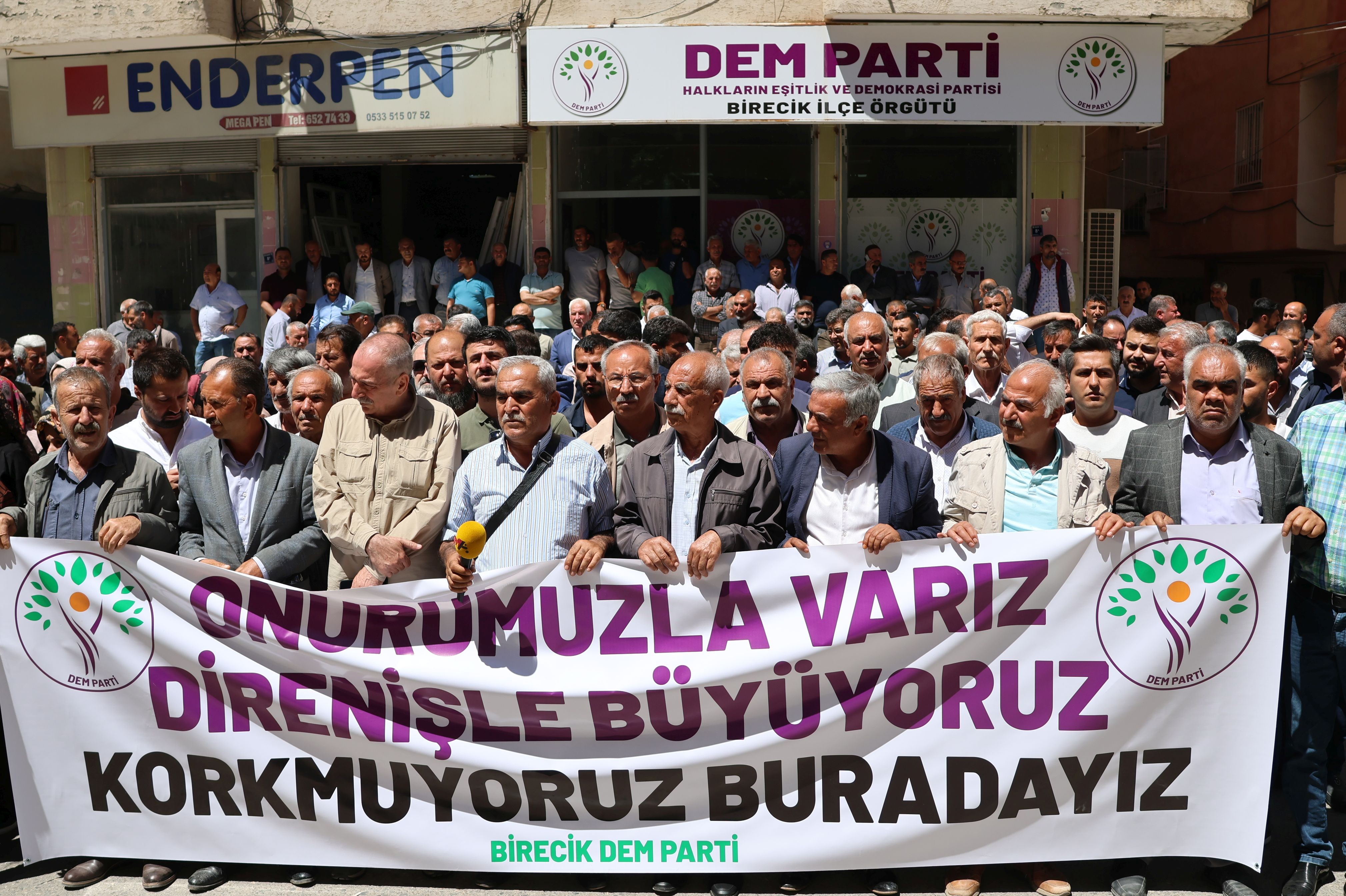 İlçe binası önünde pankart açarak basın açıklaması gerçekleştiren kalabalık